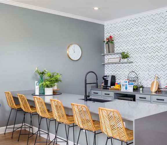 a kitchen with a large island and yellow chairs