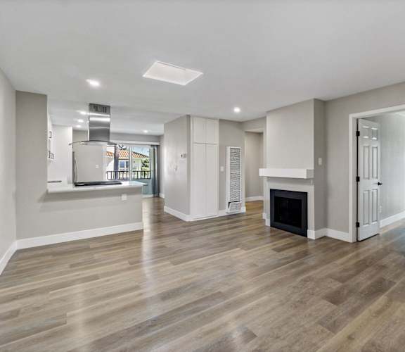 a renovated living room with a fireplace and a kitchen