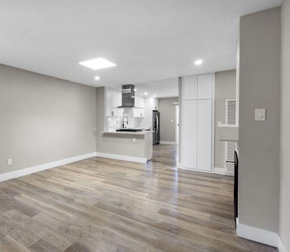 an empty room with a hard wood floor and white walls