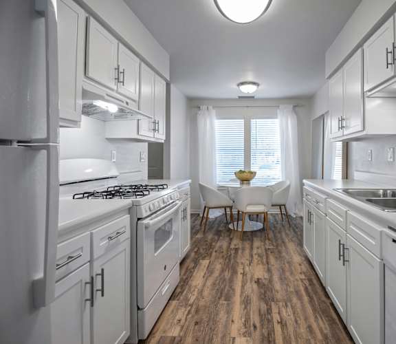 A kitchen with white appliances and wooden floors. at Estates at Palm Bay, Fort Walton Beach