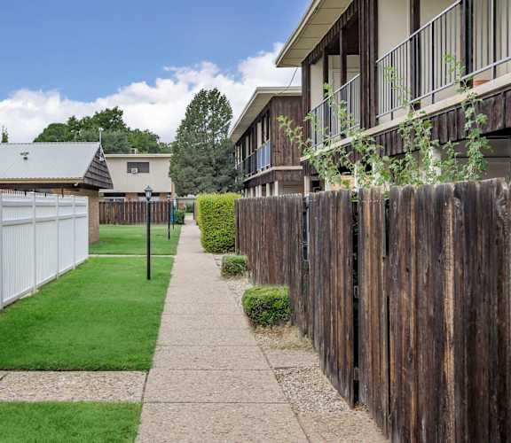 A white fence runs along the side of a building.