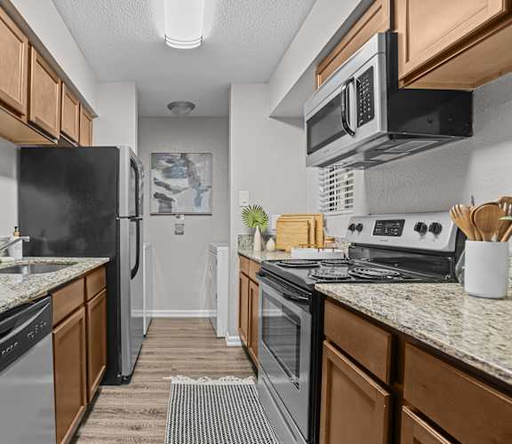A kitchen with black appliances and wooden cabinets.