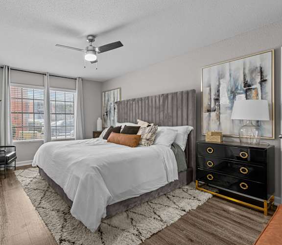 A bedroom with a large bed and a ceiling fan.