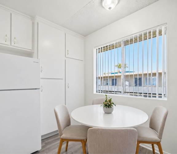 A white kitchen with a table and chairs.