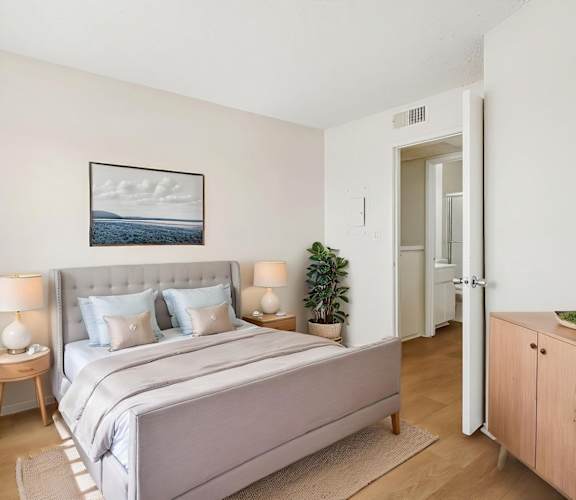 A bedroom with a large bed and a painting on the wall.