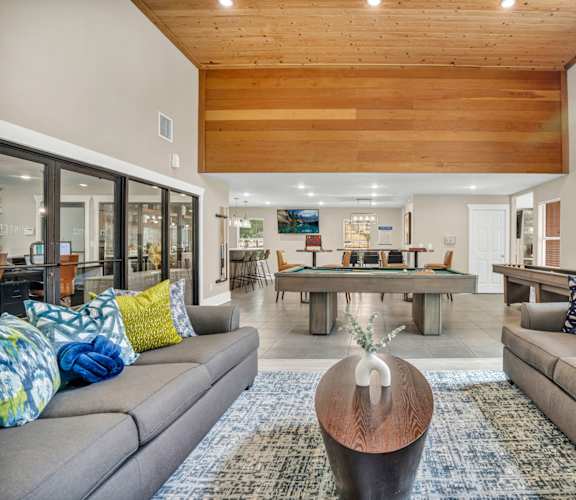 a living room with couches and a pool table