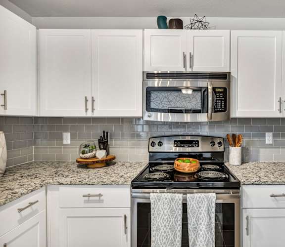 a kitchen with white cabinets and stainless steel appliances at Sunset Ridge, Texas