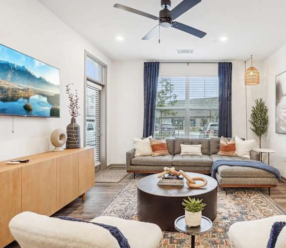 A living room with a couch, a coffee table, and a painting on the wall.