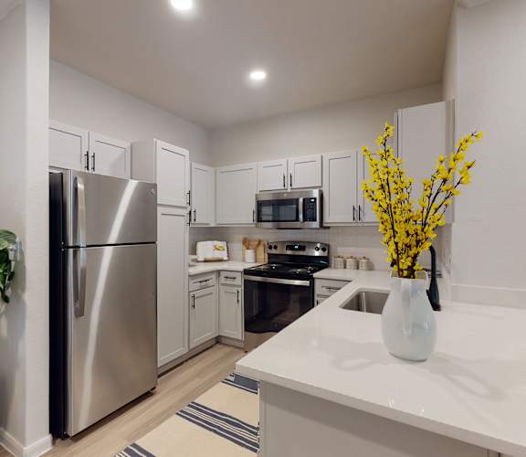 a kitchen with white cabinetry and stainless steel appliances at Remington Ranch, San Antonio, TX