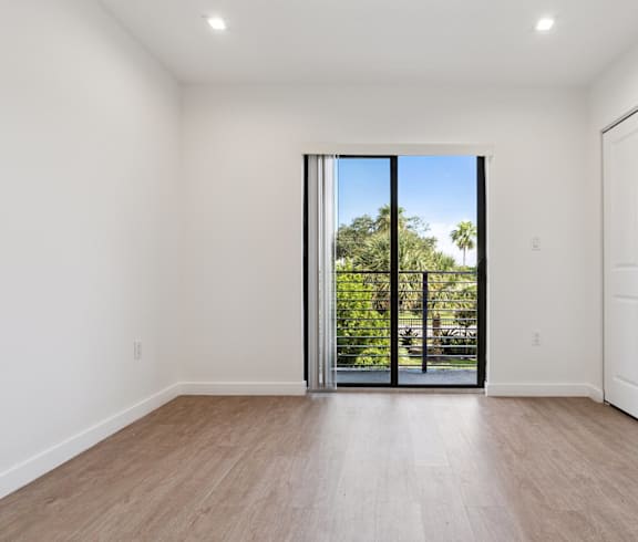 A room with a sliding glass door leading to a backyard.at The Villages at Miami Gardens, Miami, Florida, 33056