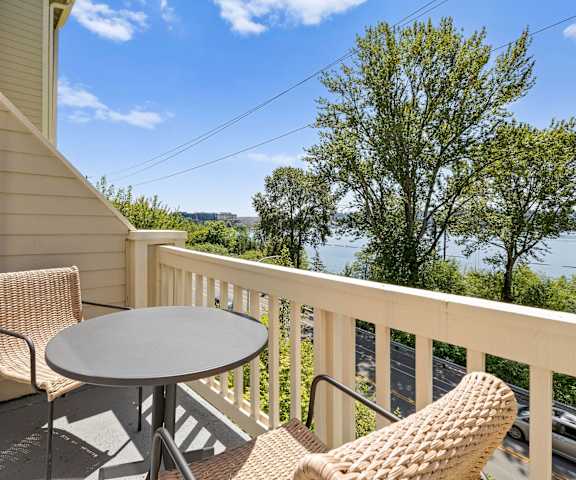 a table and two chairs sit on a balcony with a view of the water