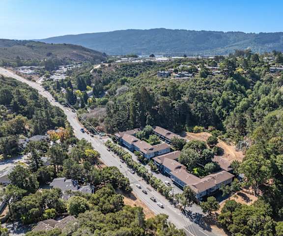 A bird's eye view of a residential area with houses surrounded by trees.