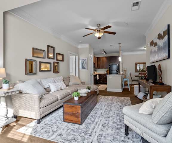 A living room with a couch, a coffee table, and a ceiling fan.