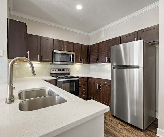 a kitchen with stainless steel appliances and white counter tops at The Verandah, Texas, 78726