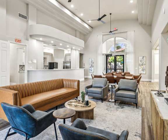 A living room with a brown couch, blue chairs, and a wooden coffee table.
