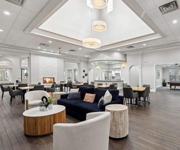 A spacious living room with a variety of seating options and a fireplace.