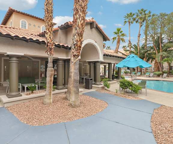 A house with a pool and a palm tree in front.