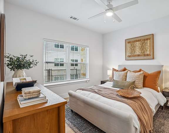 A bedroom with a large bed and a ceiling fan.