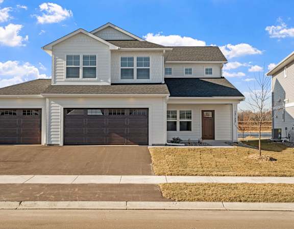 a white house with two garage doors and a driveway