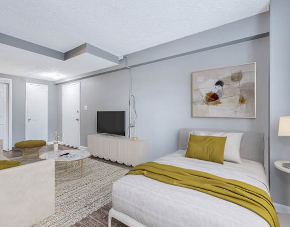 a bedroom with a bed and a couch and a tv at Lofts on Ormsby, Louisville, KY 40203