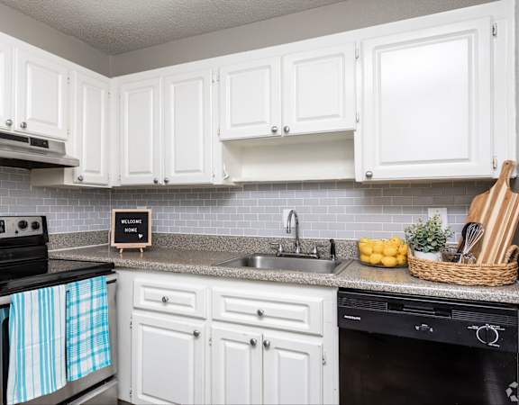 A kitchen with white cabinets and a black stove top.