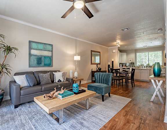 A living room with a grey couch, a wooden coffee table, and a ceiling fan.at Palazzo Townhomes, Phoenix, AZ