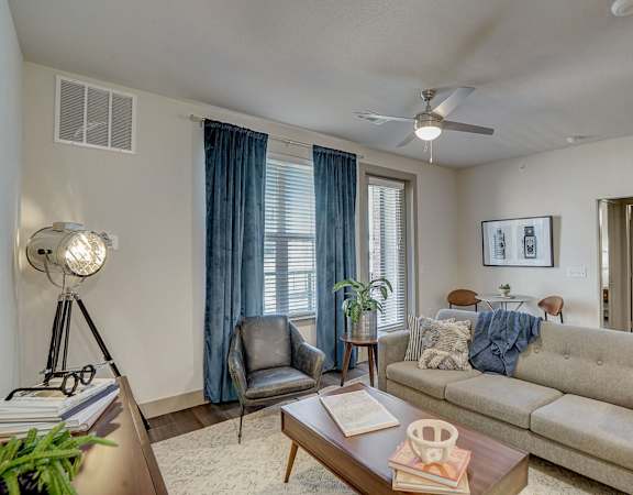 A living room with a grey couch, a chair, a table, and a floor lamp.