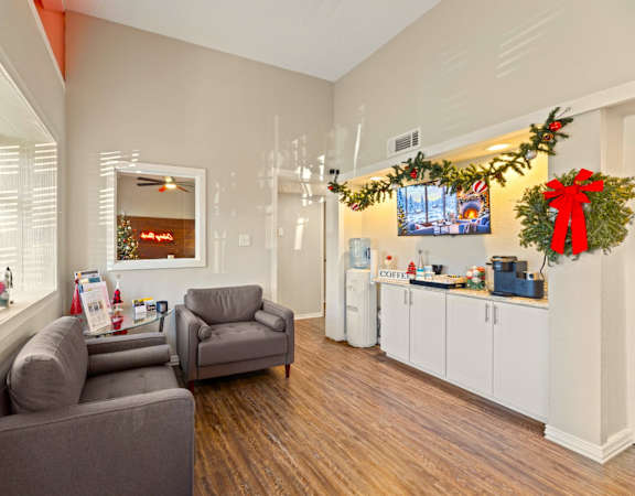 A living room with a grey couch and a Christmas tree.