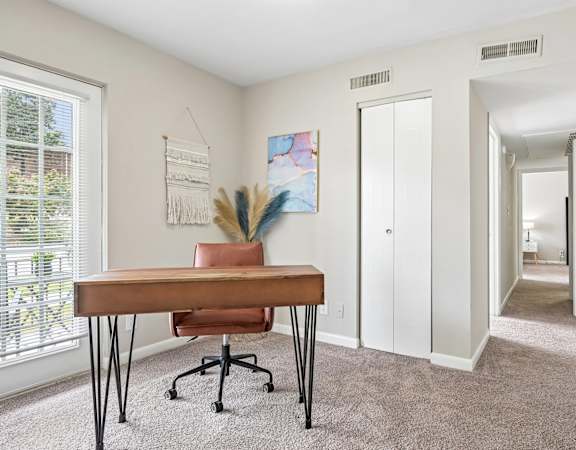 A room with a brown table and a painting on the wall.