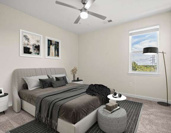 A bedroom with a large bed and a ceiling fan.