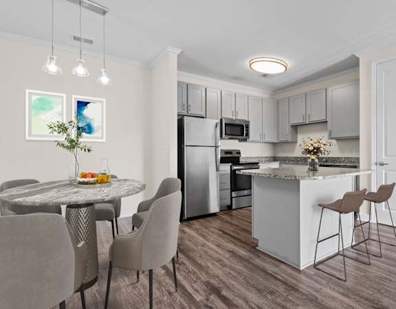 A modern kitchen with a dining table and chairs.