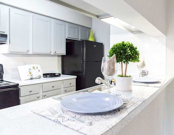 a white kitchen with white cabinets and black appliances