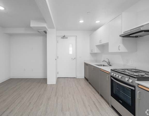 A kitchen with a stove top oven and a sink.