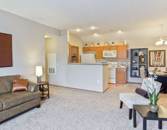 a living room and kitchen with a couch and a table