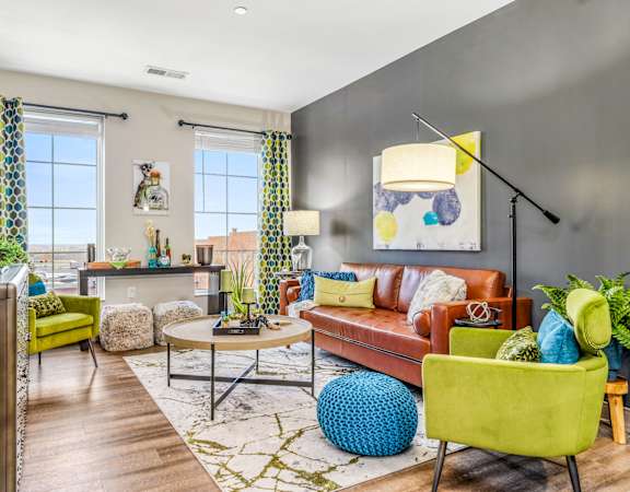a living room with a brown couch and yellow chairs