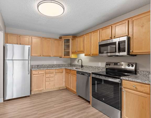 A kitchen with wooden cabinets and stainless steel appliances.