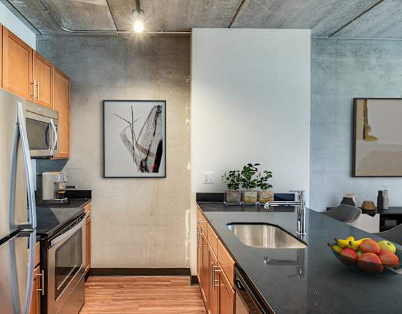 a kitchen with stainless steel appliances and black counter tops and a sink