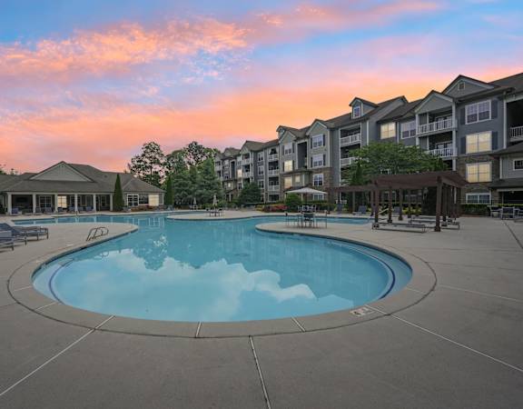A large swimming pool surrounded by apartment buildings.