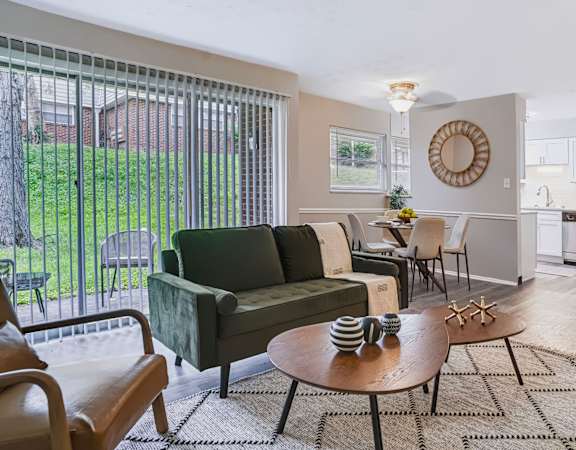 A living room with a green couch and a wooden coffee table.