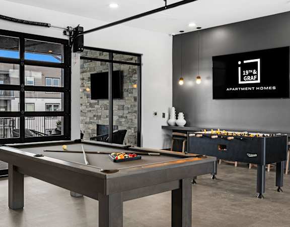 A pool table in a room with a TV and a fireplace.