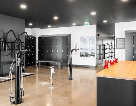 A gym with a row of treadmills and a wooden counter.