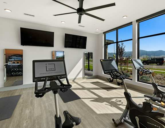 a home gym with exercise machines and a large window