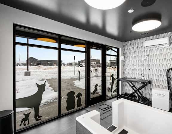 A bathroom with a large mirror and a dog silhouette on the window.