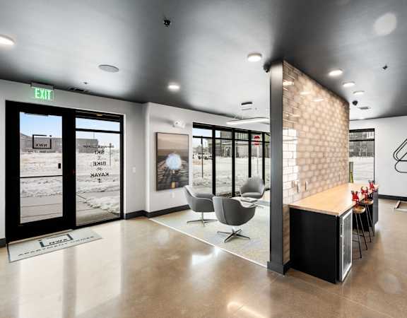A modern office lobby with a reception desk and chairs.