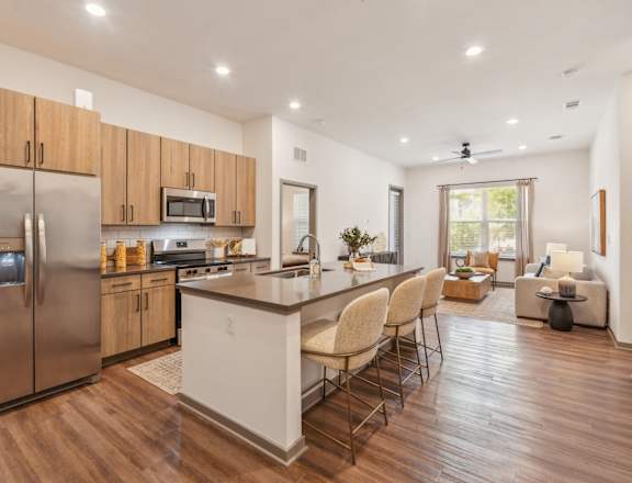 A modern kitchen with wooden cabinets and a stainless steel refrigerator.