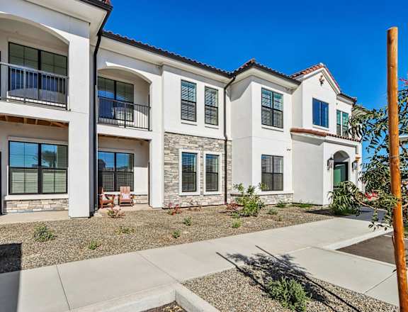 an exterior view of three buildings with a sidewalk in front of them at Stella Luxury Apartment Homes, San Tan Valley, AZ, 85143