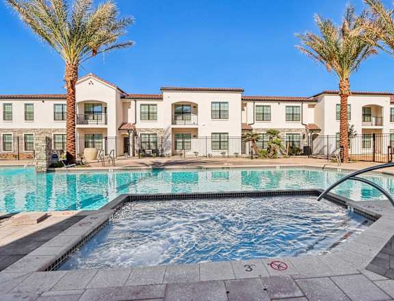 a swimming pool with palm trees and apartments in the background at Stella Luxury Apartment Homes, Arizona, 85143