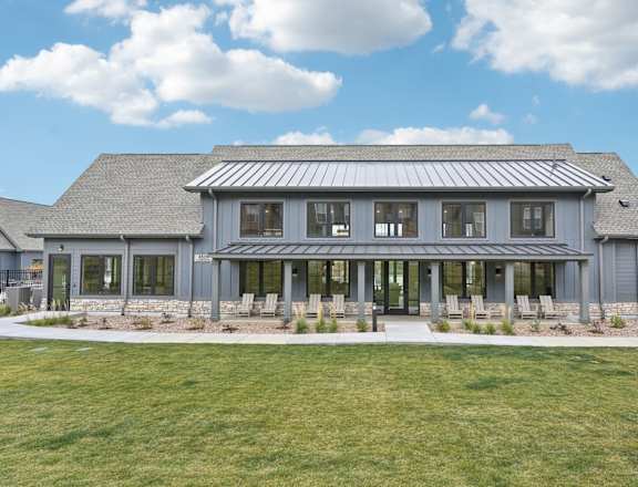 the front of a gray house with windows and a lawn at The Garrison Luxury Apartment Homes, Colorado, 80817