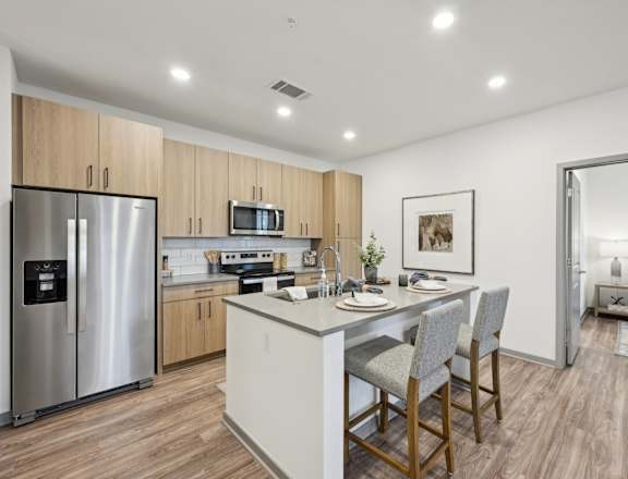 a kitchen with a large island and a stainless steel refrigerator at The Garrison Luxury Apartment Homes, Colorado, 80817