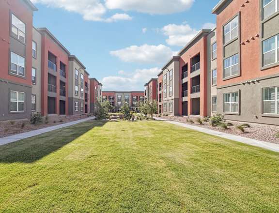 a grassy area in front of an apartment building at The Maddox Luxury Apartment Homes, Arizona